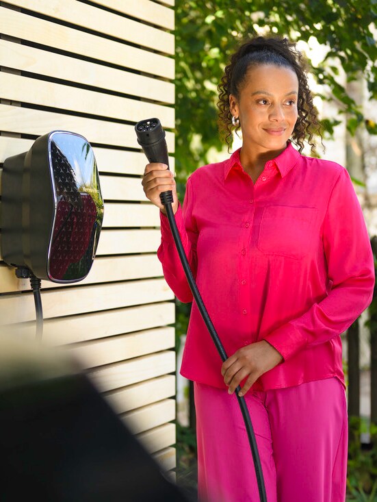 Bir kişi bir Mercedes-Benz aracını Mercedes-Benz duvar tipi şarj ünitesi ile şarj ediyor