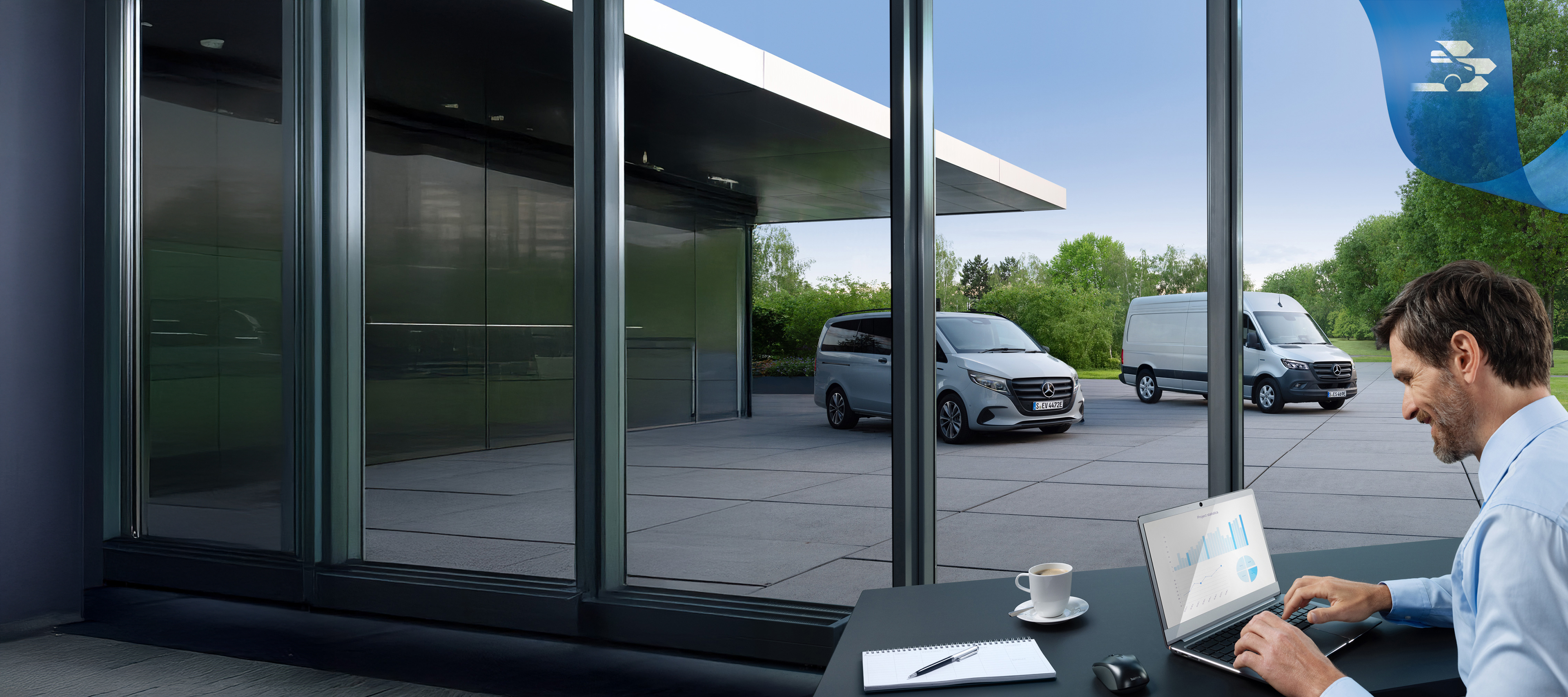 Mercedes-Benz | Hafif Ticari Araç ServiceCare Arka planda bir dizi Mercedes-Benz hafif ticari araç ile ofiste bir adam dizüstü bilgisayarı kullanıyor.