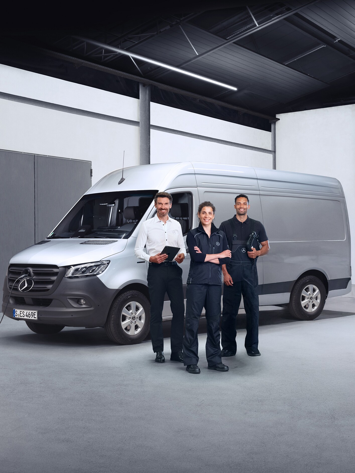 Kaliteyi simgeleyen Mercedes-Benz hafif ticari araçların önünde duran üç çalışan.