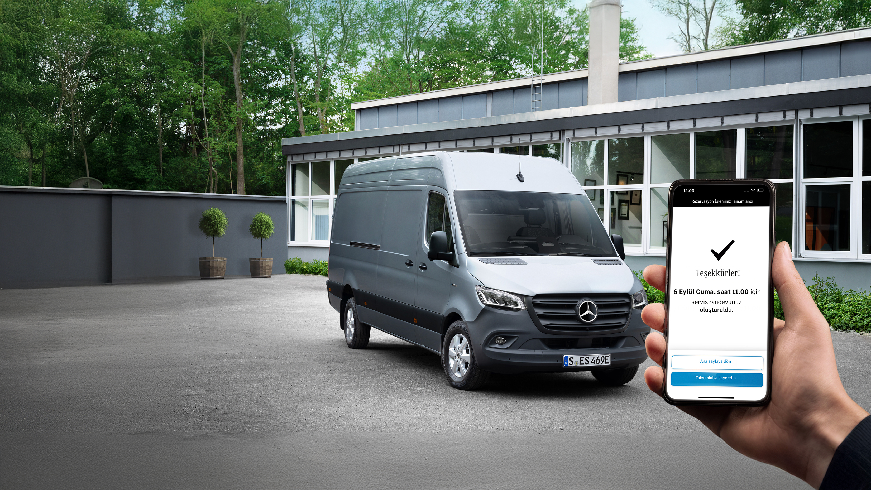 Mercedes-Benz | Konfor | Servis Partneri Ön planda akıllı telefon tutan bir kişi ile bir ofis önünde gri bir Mercedes-Benz Sprinter hafif ticari araç.