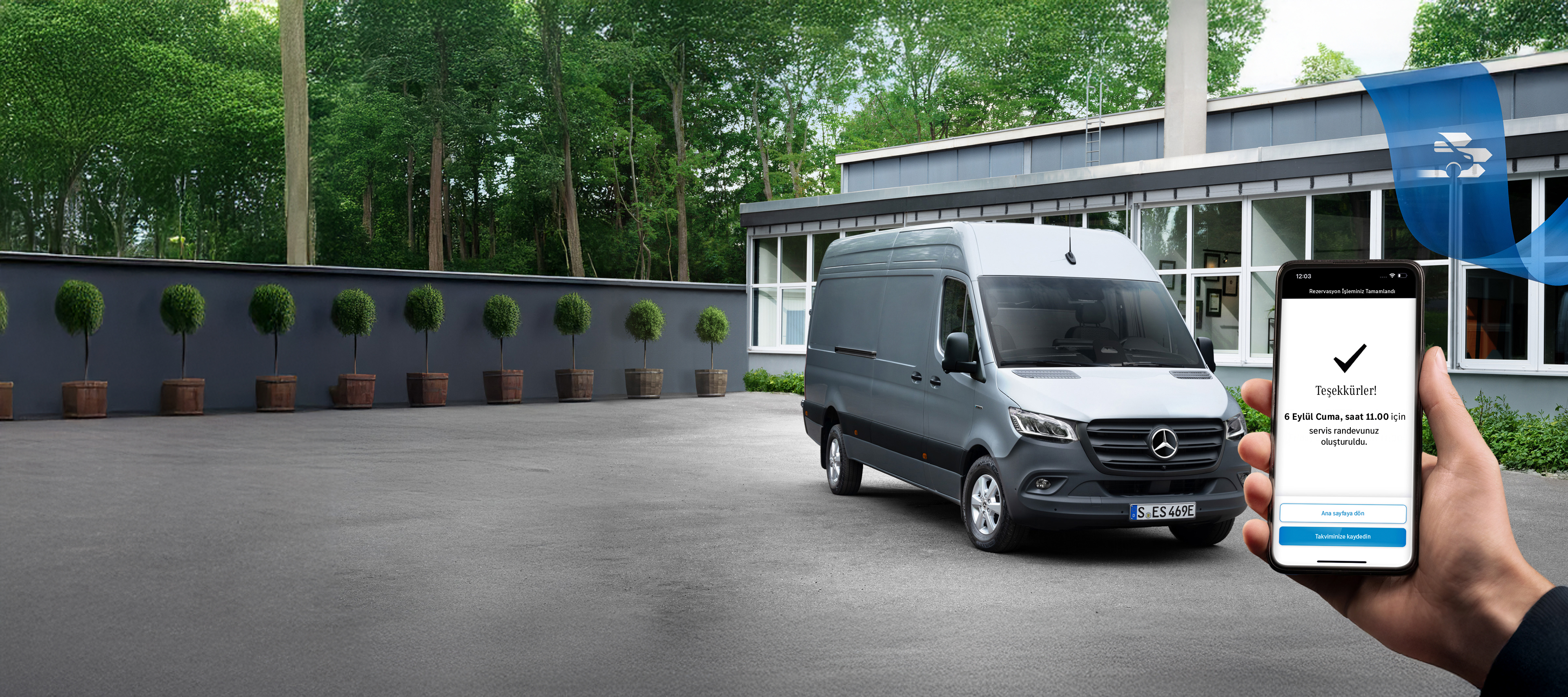 Mercedes Benz | Konfor | Çevrimiçi randevu rezervasyonu Ön planda akıllı telefon tutan bir el ile bir ofis önünde gri bir Mercedes-Benz Sprinter hafif ticari araç.
