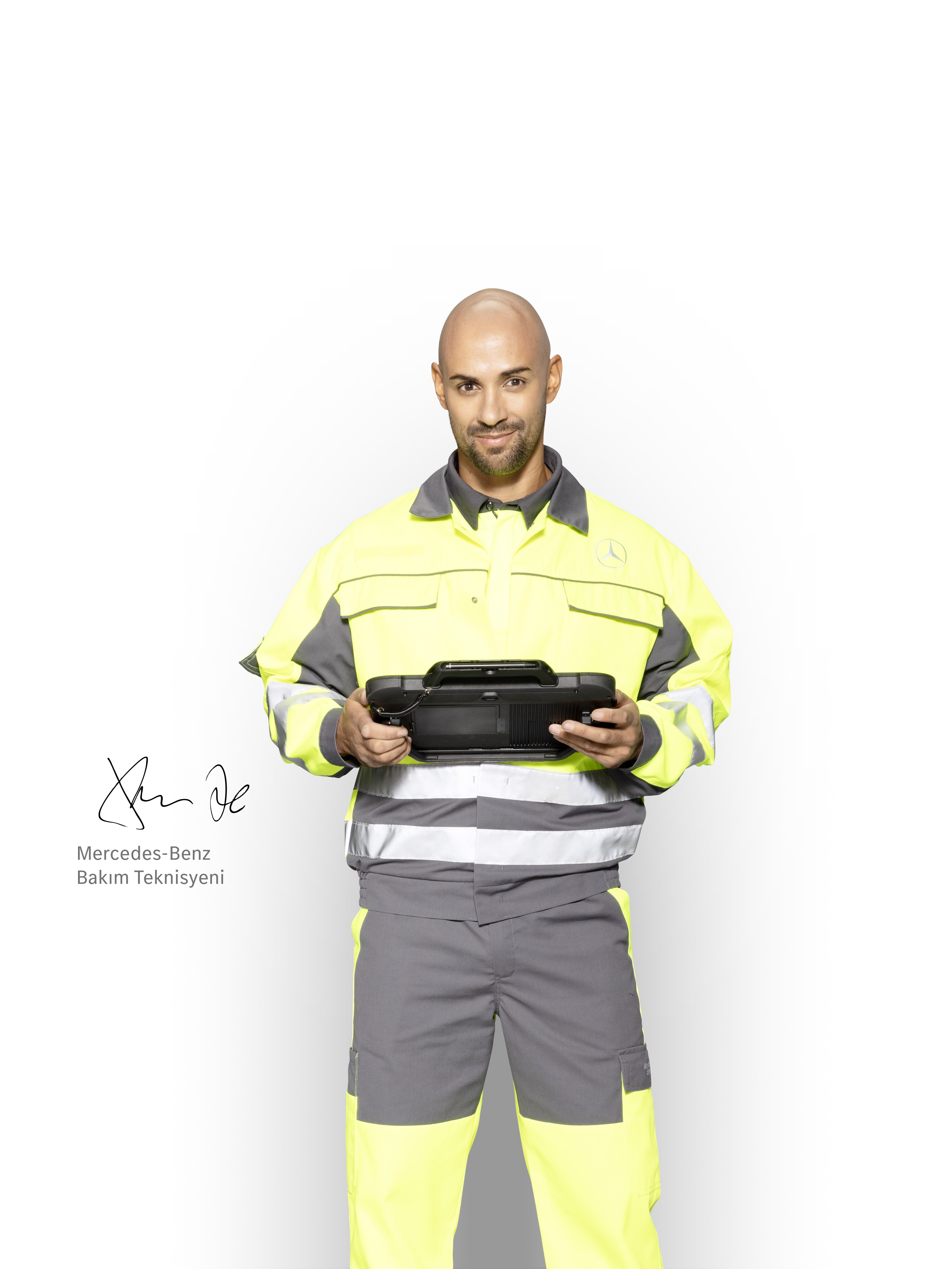 Mercedes-Benz'den yetkin destek sağlamak için iş kıyafeti giymiş ve elinde tablet bulunan servis teknisyeni.