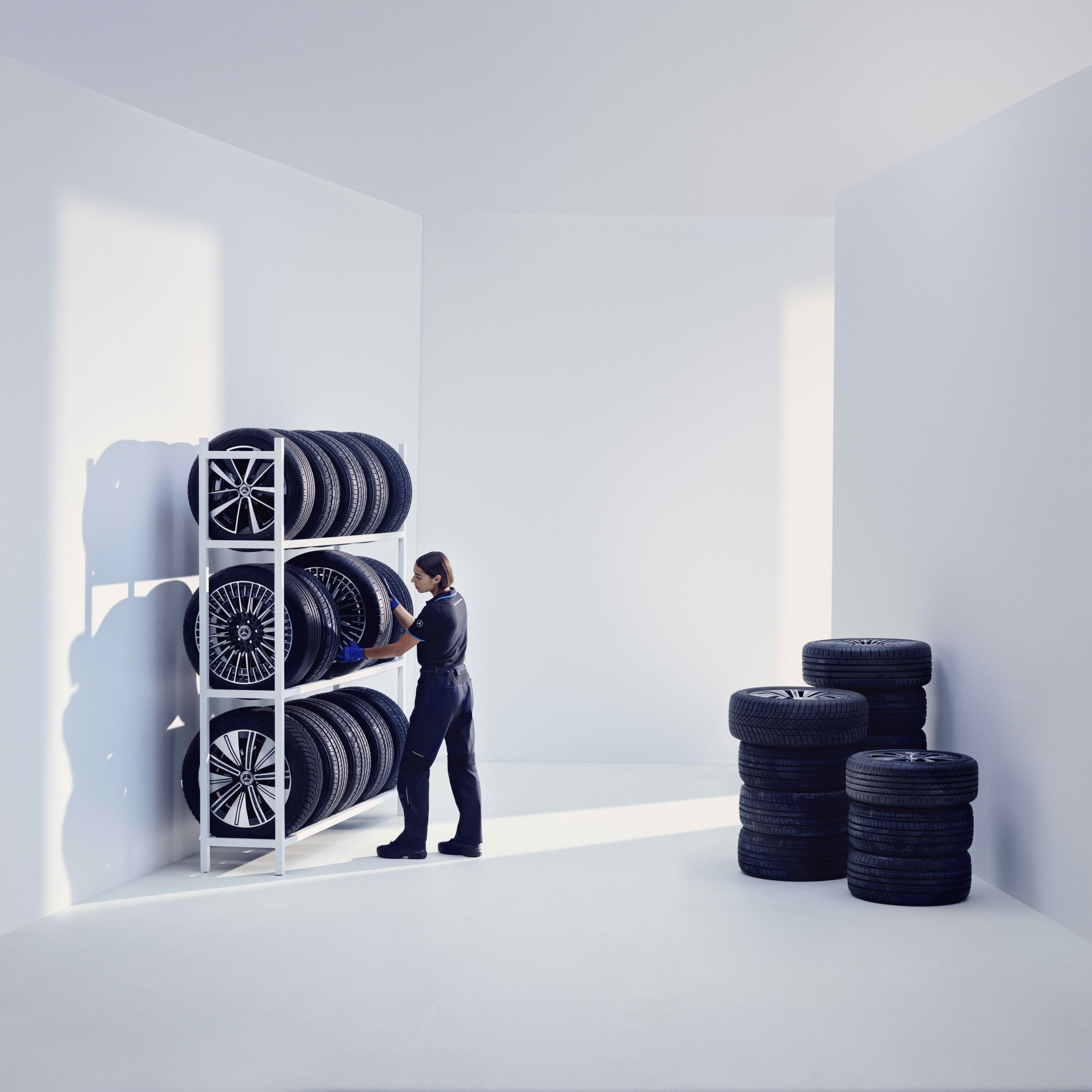 Bir Mercedes-Benz teknisyeni, Mercedes-Benz orijinal lastikleri bir rafa depolarken.