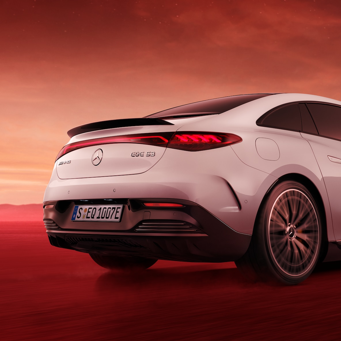 Alttan görünen arka kapak ve spoylerin yakından görünümüyle, Mercedes-AMG EQE 53 4MATIC+'nın arka görünümü.