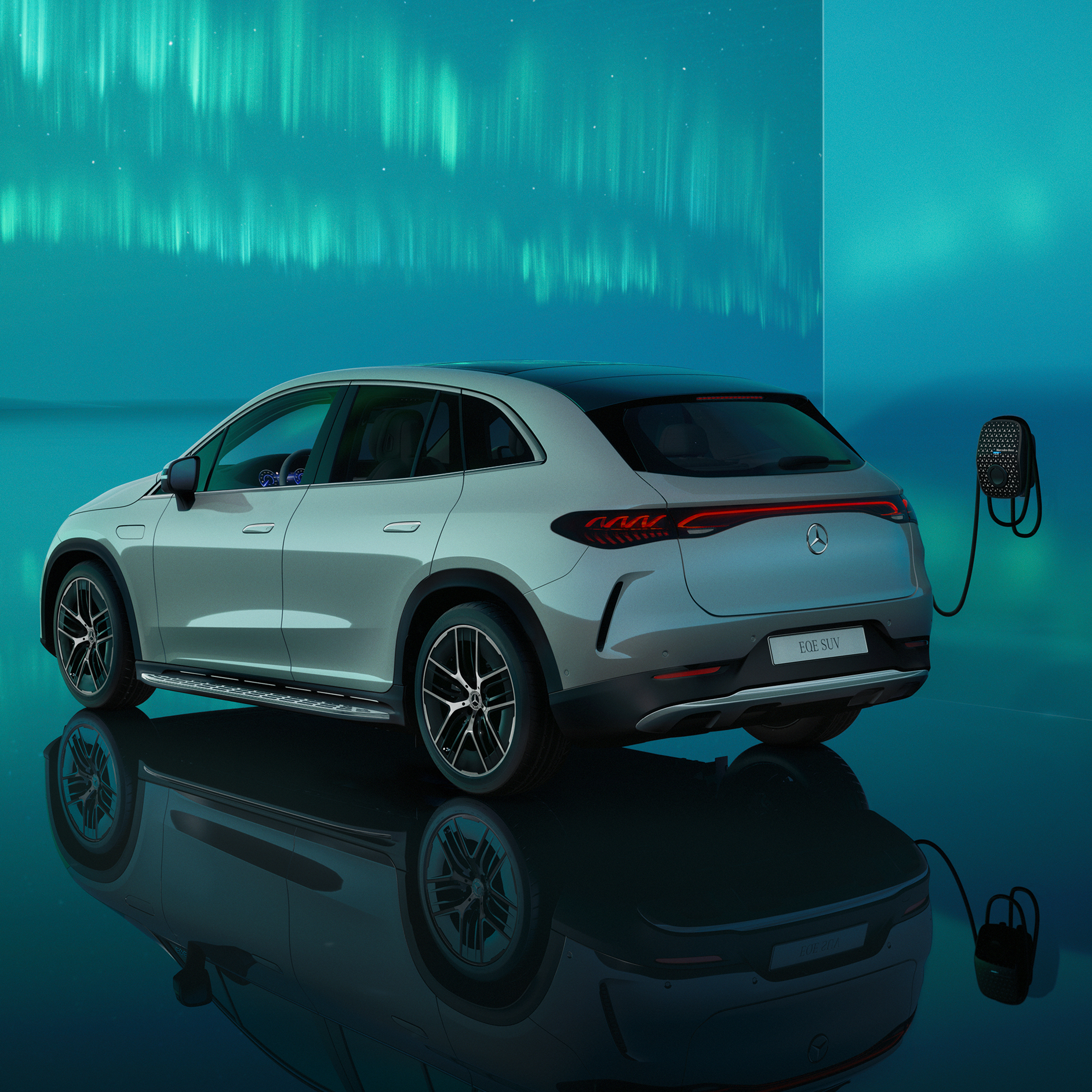 Şarj | Elektrikli araçlar | Mercedes-Benz Bir Mercedes Benz duvar tipi şarj ünitesinde şarj olan EQE SUV'nin arka yan perspektiften görünümü.