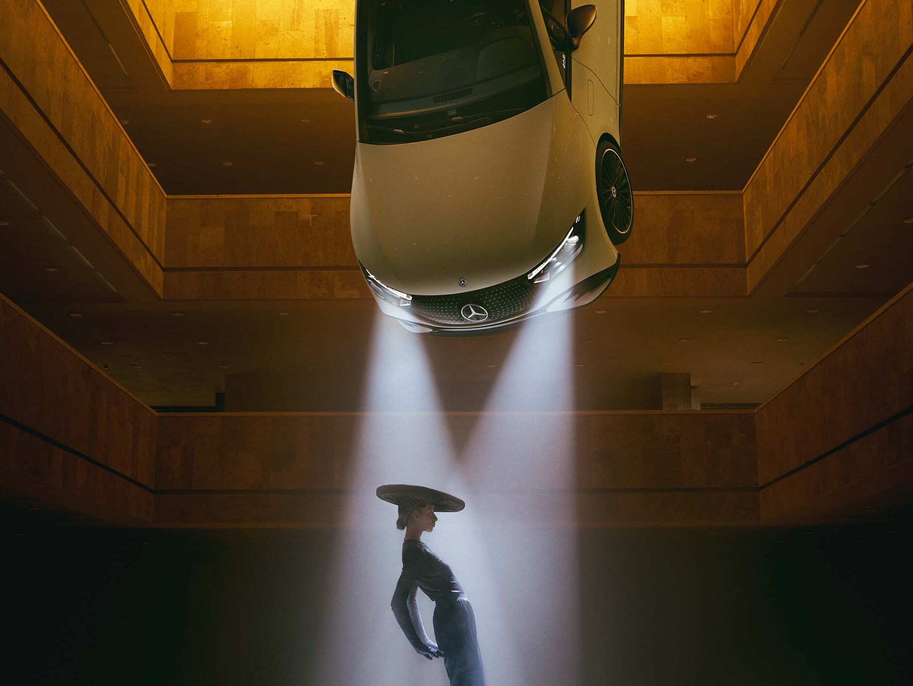 Tavanından farlar sarkan karanlık bir oda ve ışık konisinin içinde duran bir kadın.