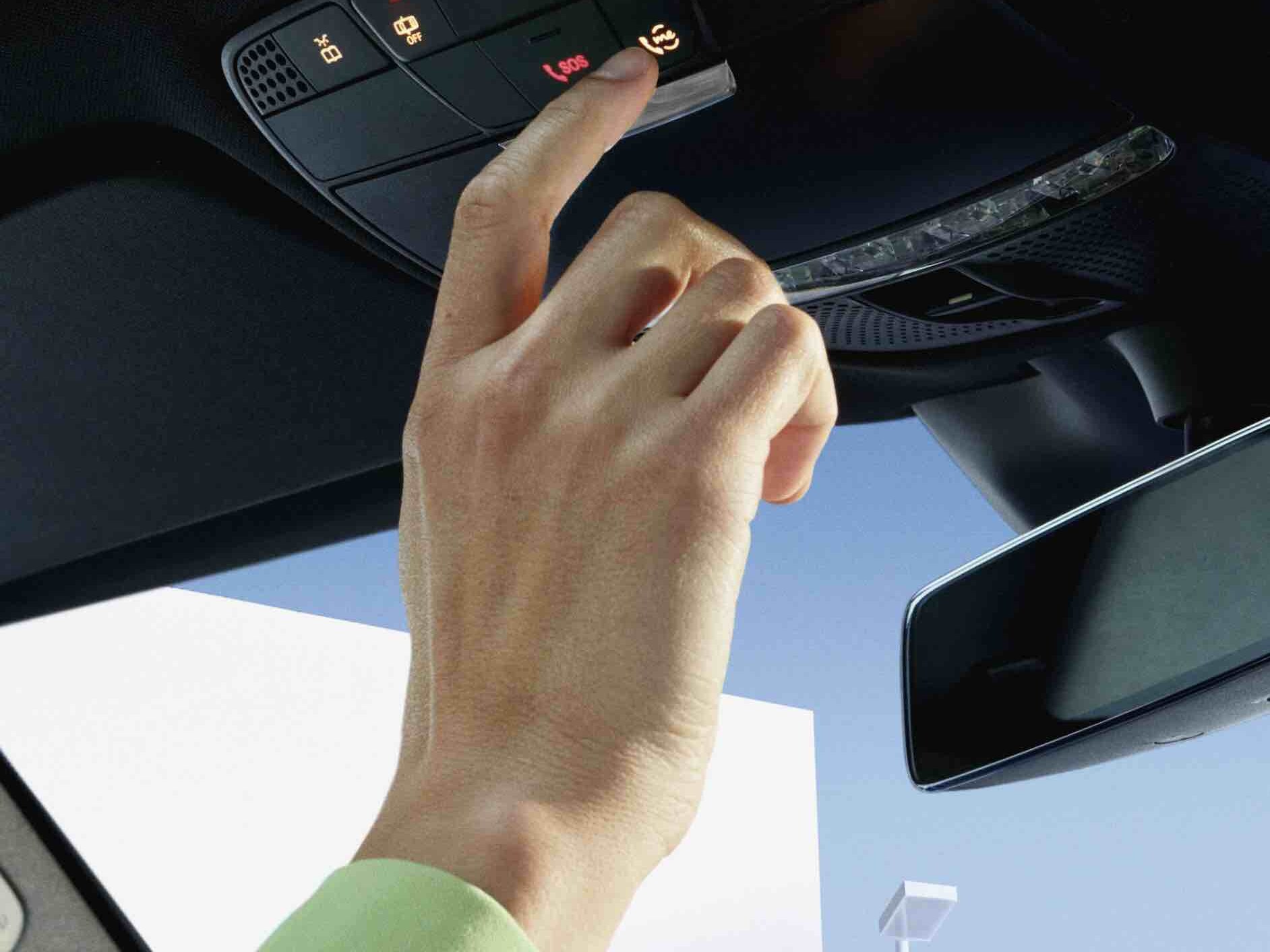 Kontrol panelindeki Mercedes me düğmesine basan bir kişi