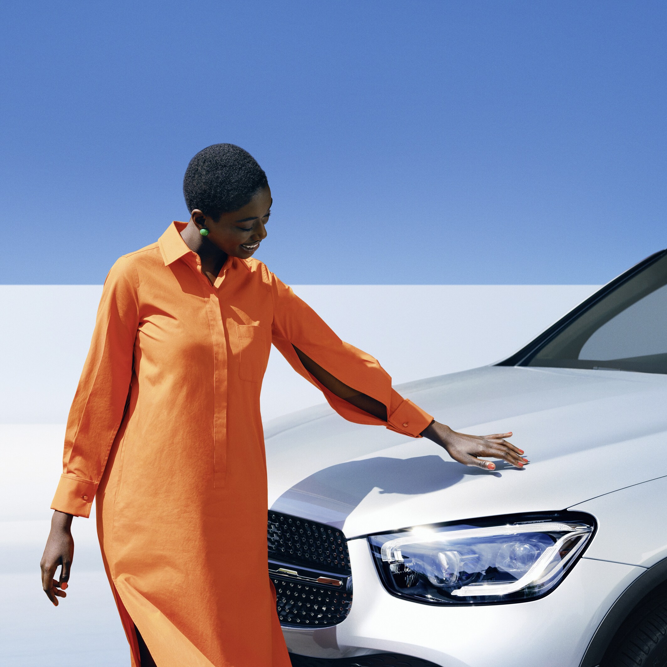Bir kadın Mercedes-Benz'ini inceliyor.