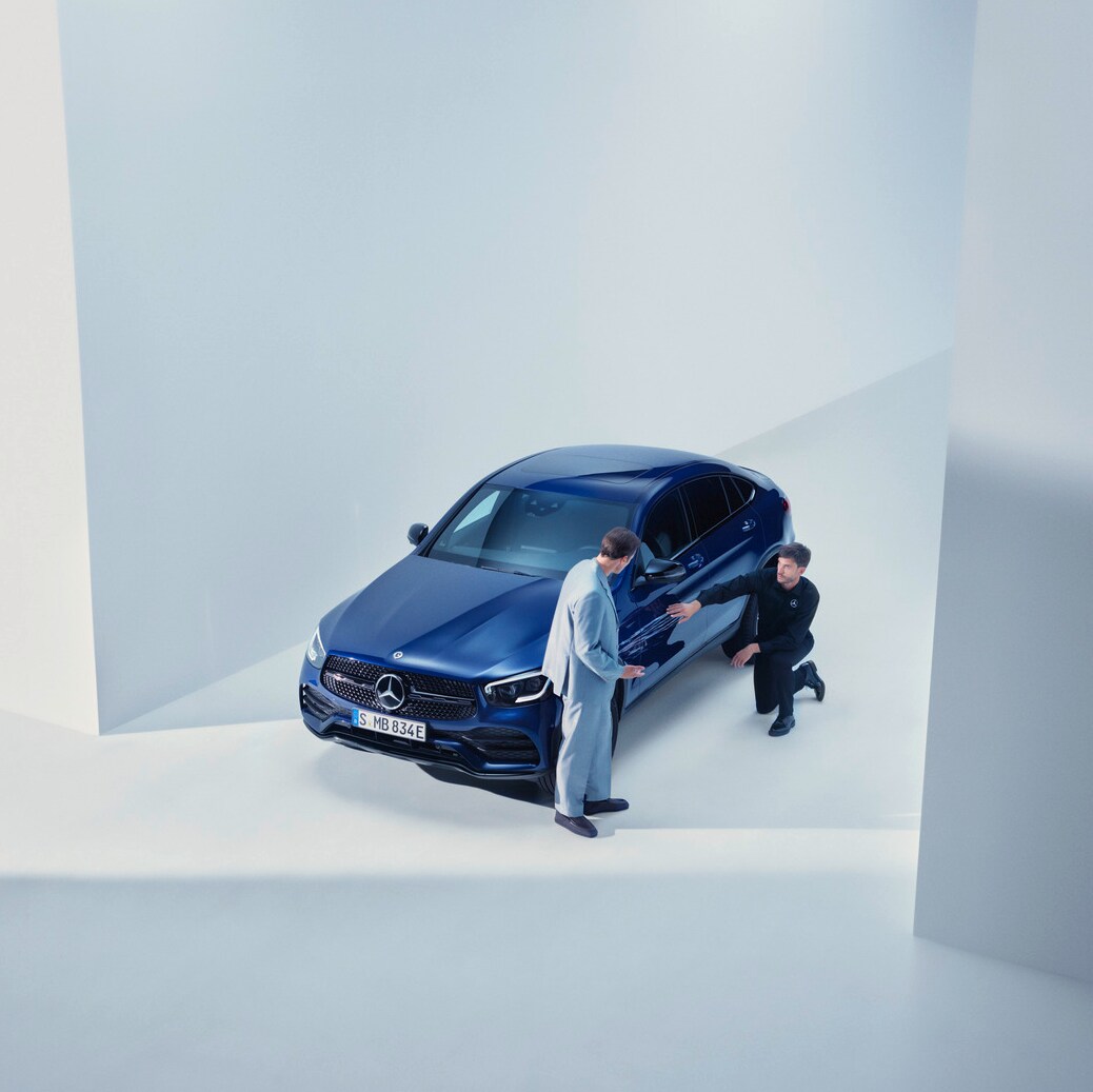 Elinde telefonuyla Mercedes-Benz'inin önünde duran ve bir görüşme yapan kadın