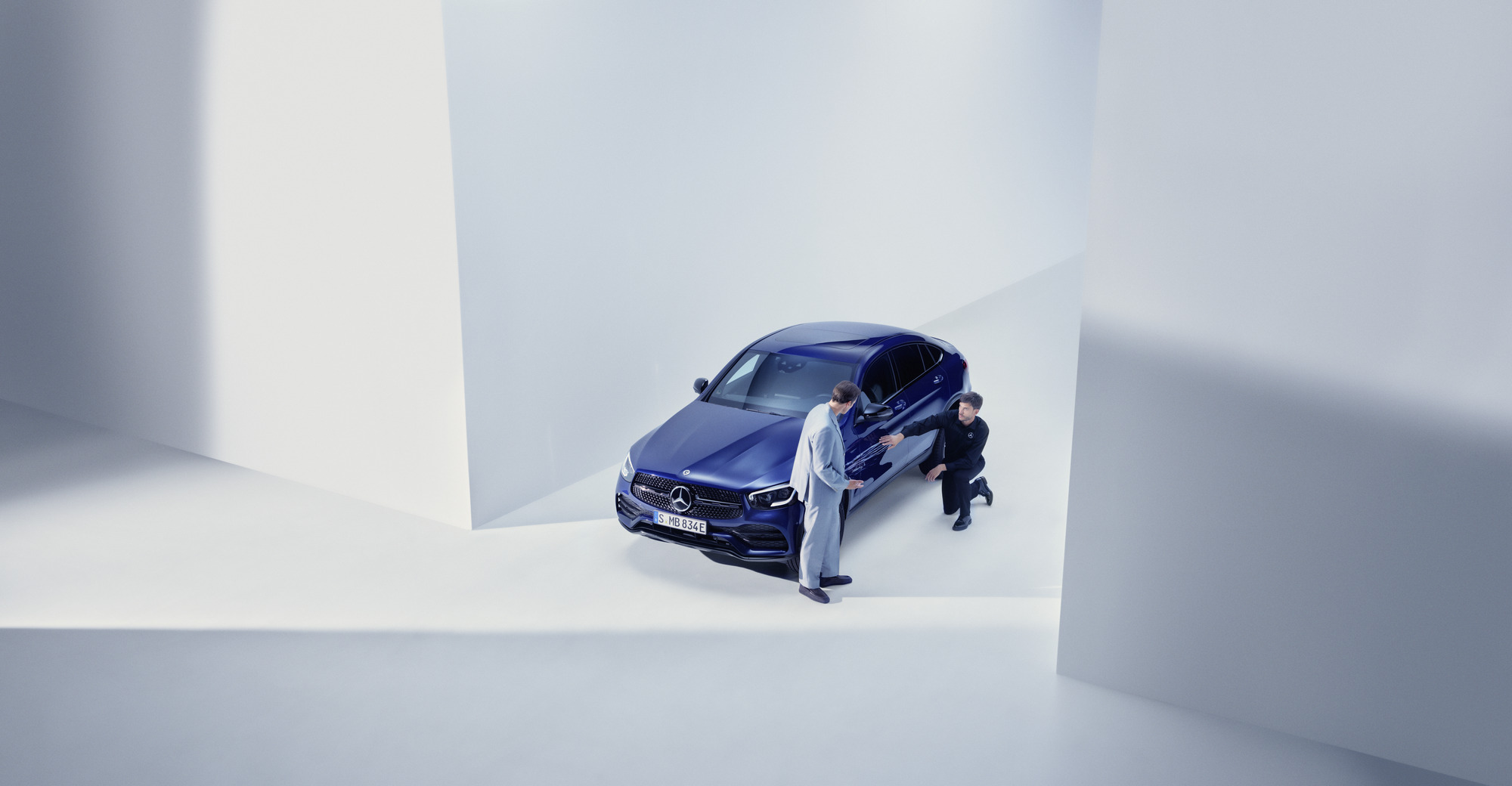 Hasar ve Arıza Yardımı | Mercedes-Benz Elinde telefonuyla Mercedes-Benz'inin önünde duran ve bir görüşme yapan kadın