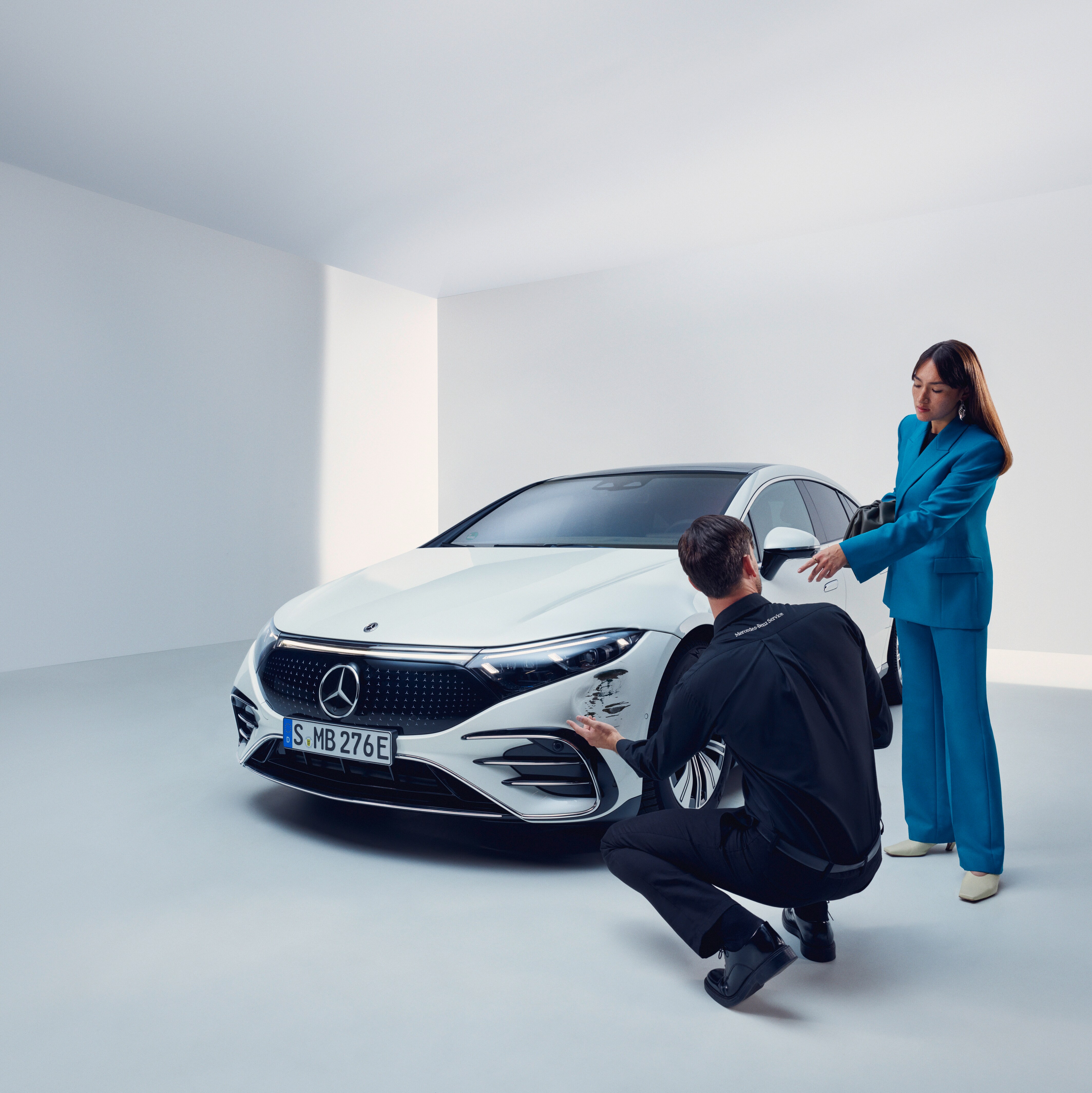 Bir adam Mercedes-Benz aracını inceliyor.