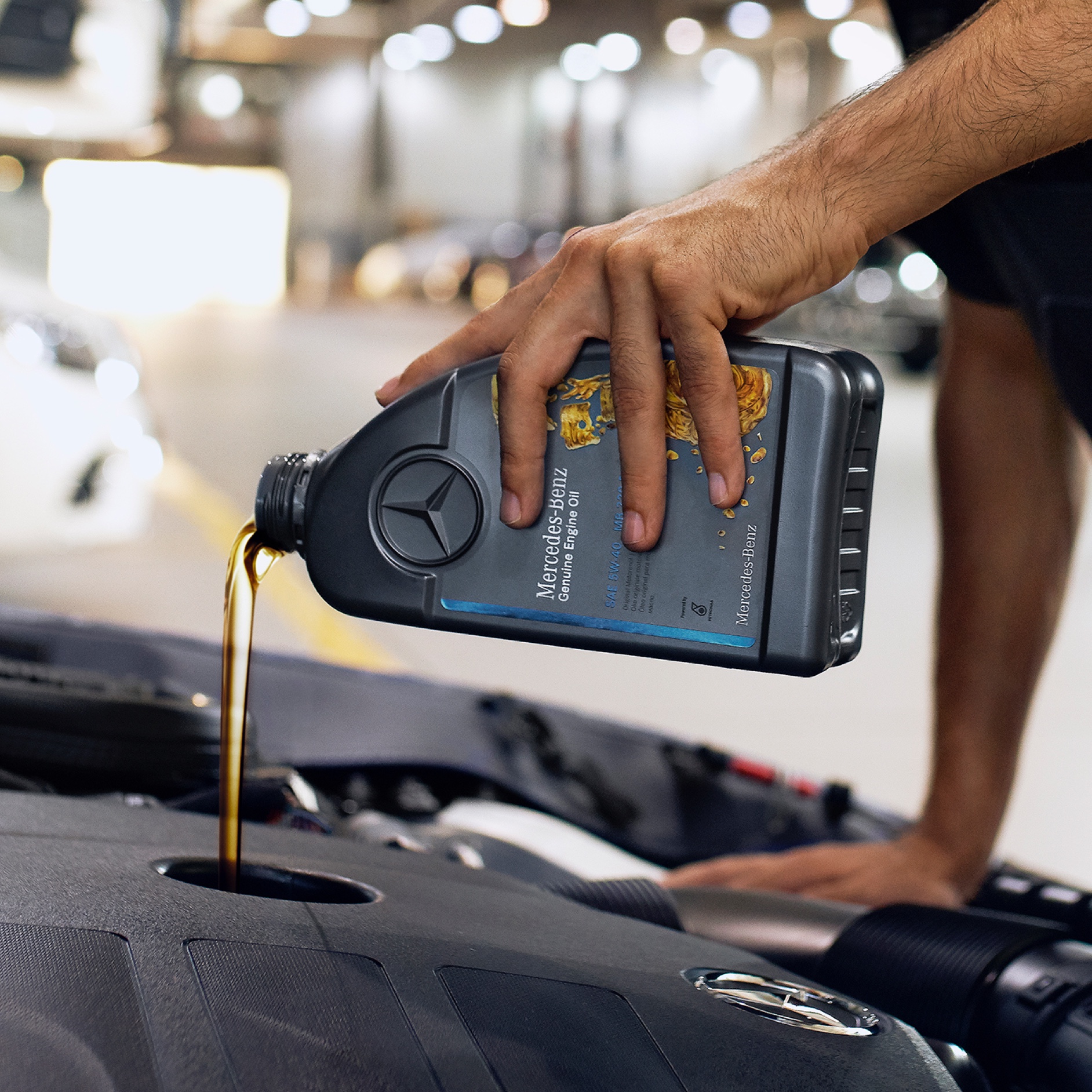 Motor yağı | Mercedes-Benz Bir Mercedes-Benz aracına motor yağ dolduran bir kişi.