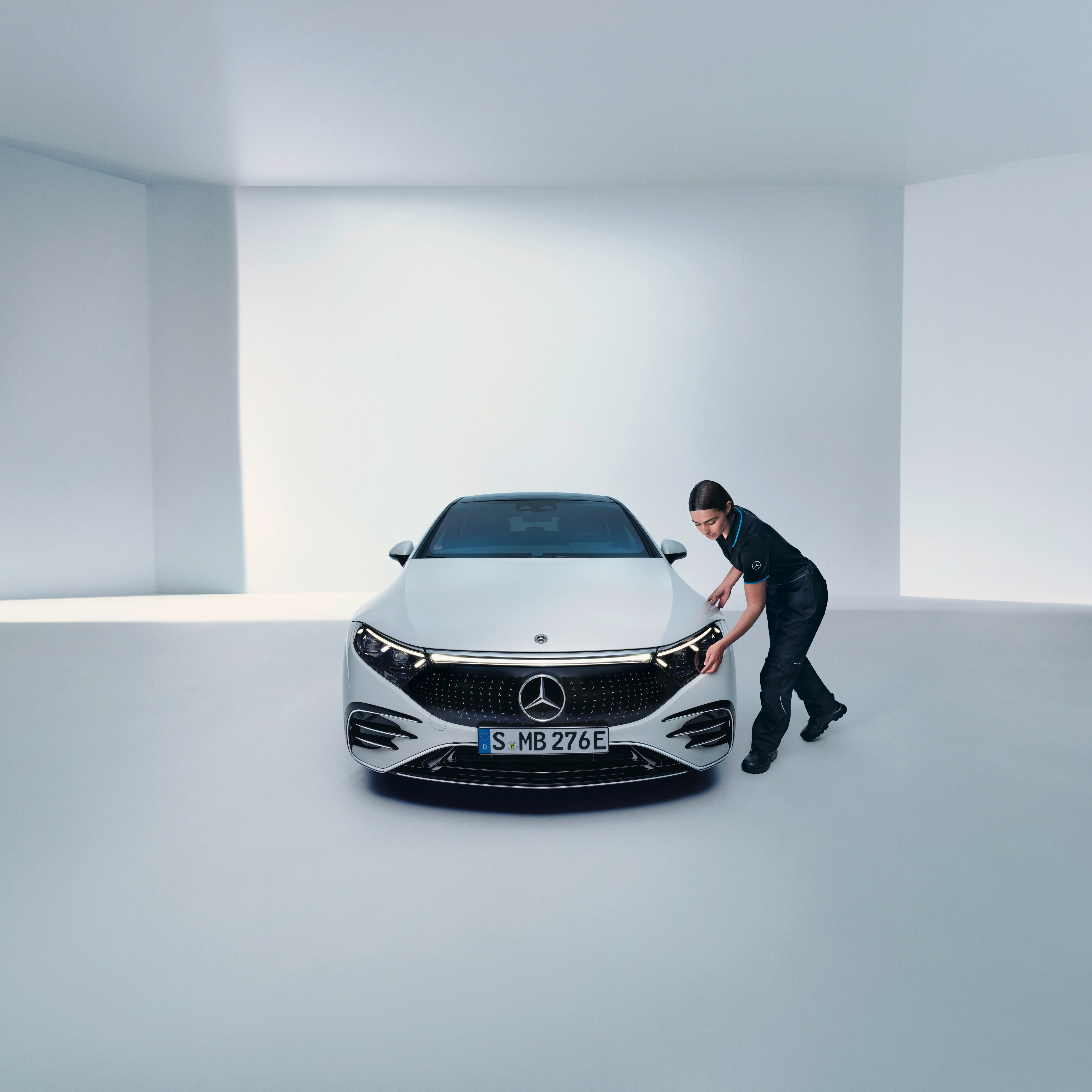 Bir Mercedes-Benz teknisyeni bir farı kontrol ediyor.