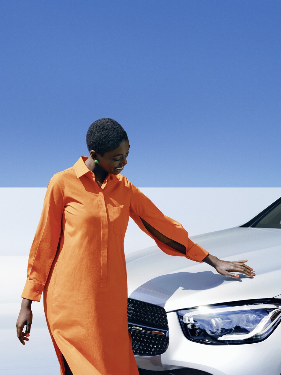 Bir Mercedes-Benz aracın yanında duran bir kişi.