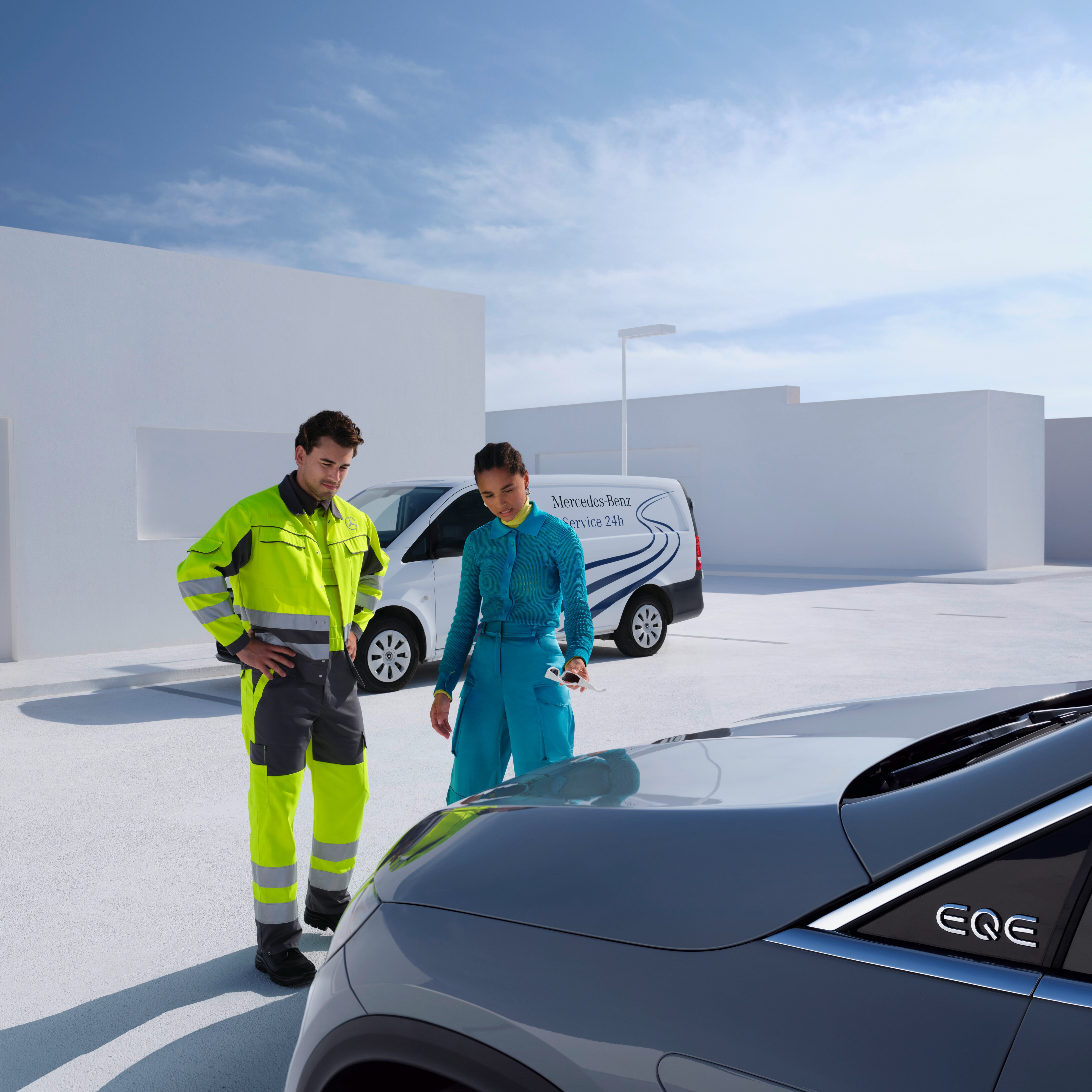 Mercedes-Benz Servis ekibinden bir erkek ve kadın Mercedes-Benz'e bakıyor