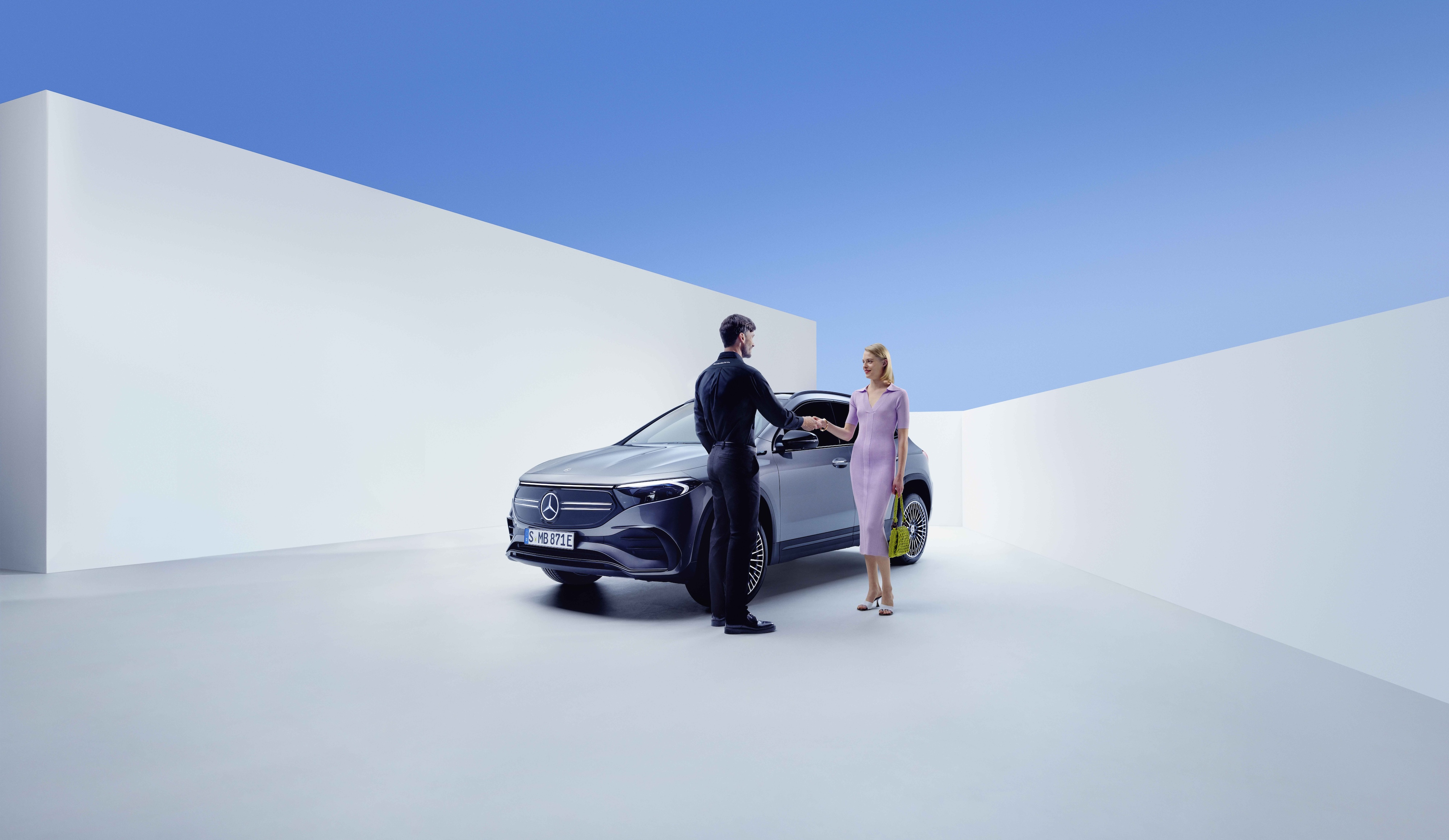 Servis ve Onarım | Mercedes-Benz Bir Mercedes-Benz çalışanı ile bir kadın, bir Mercedes-Benz'in önünde el sıkışıyor