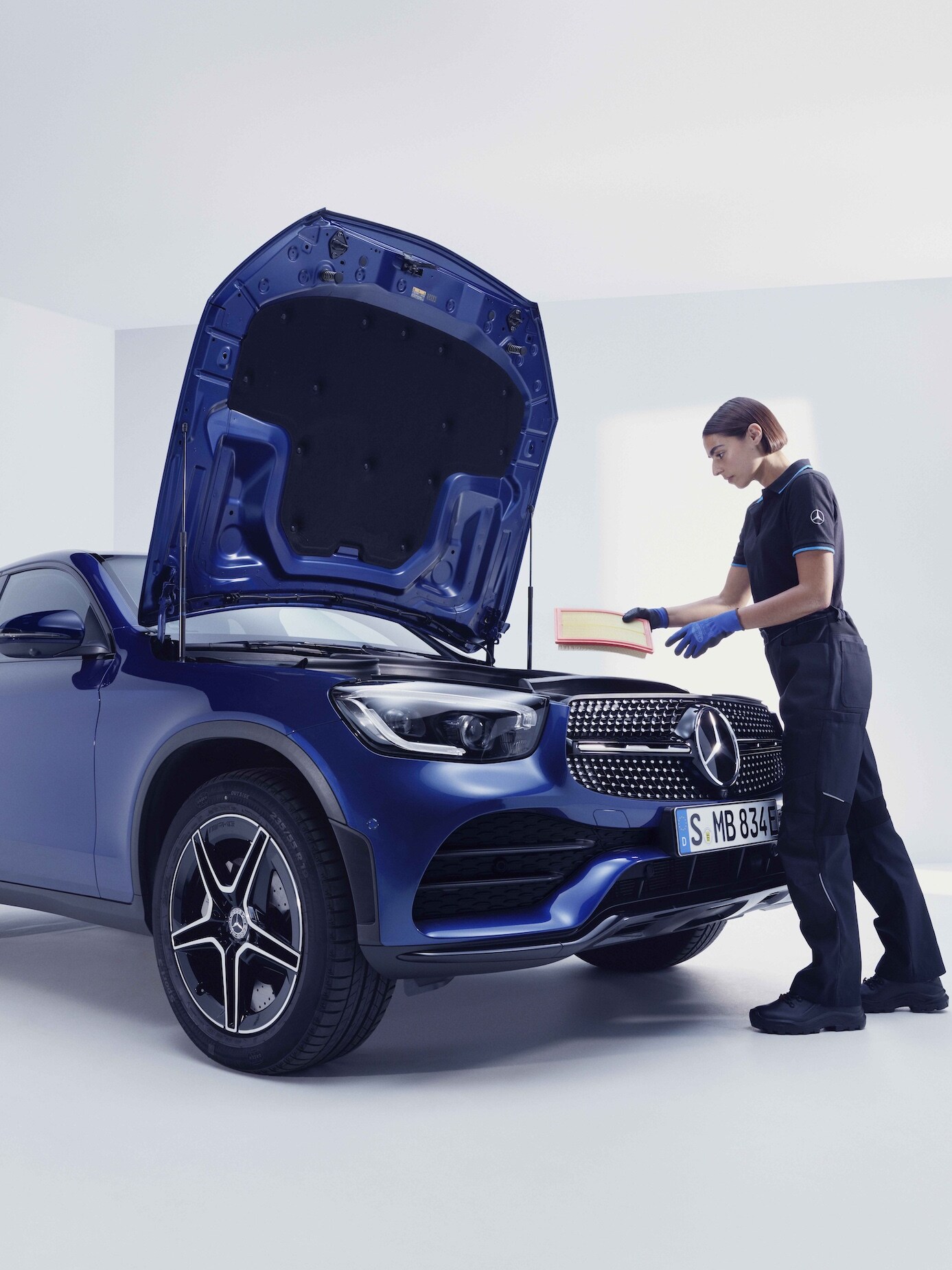 Bir Mercedes-Benz'i muayene eden bir Mercedes-Benz teknisyeni.