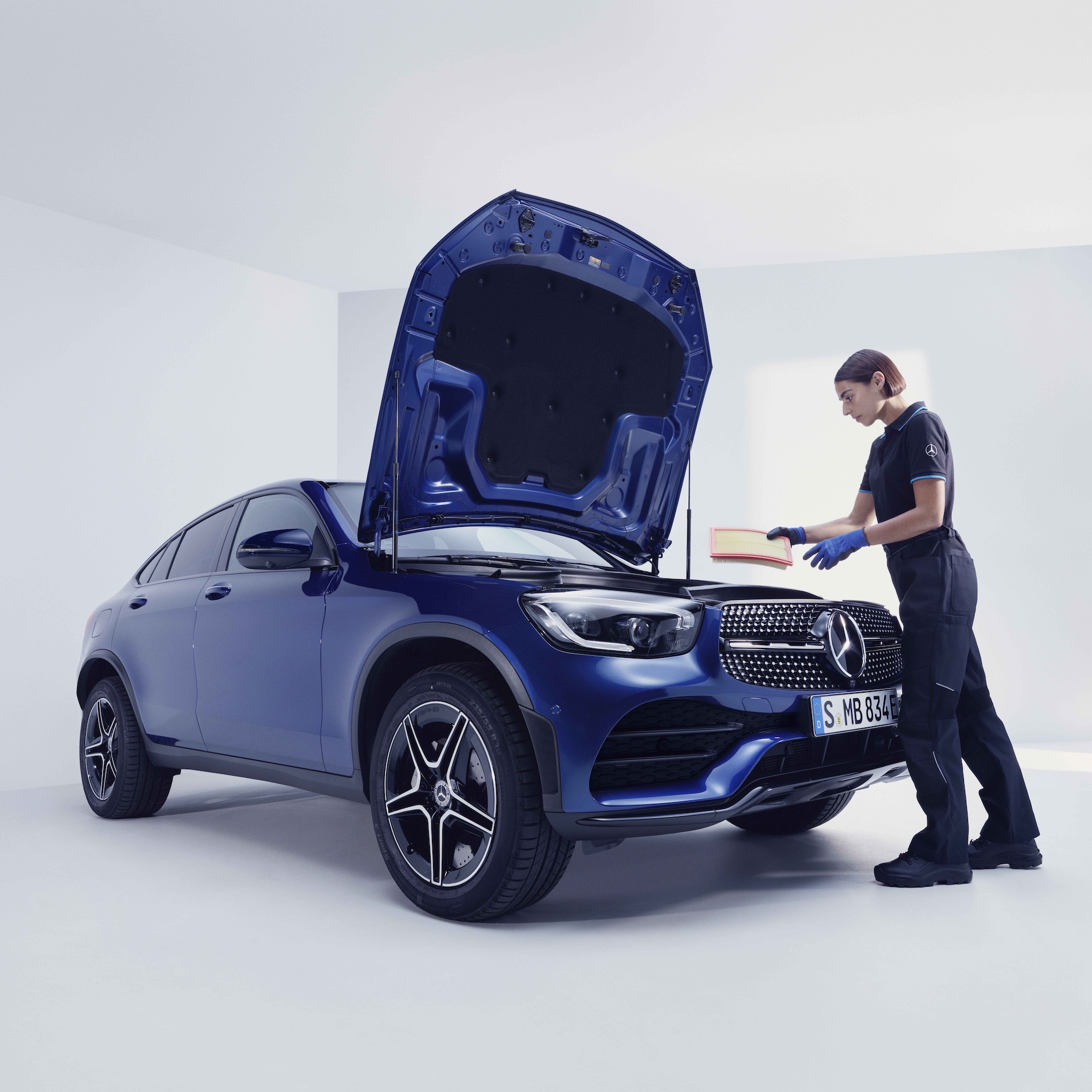 Elektrikli araçların bakımı | Mercedes-Benz Bir Mercedes-Benz'i muayene eden bir Mercedes-Benz teknisyeni.