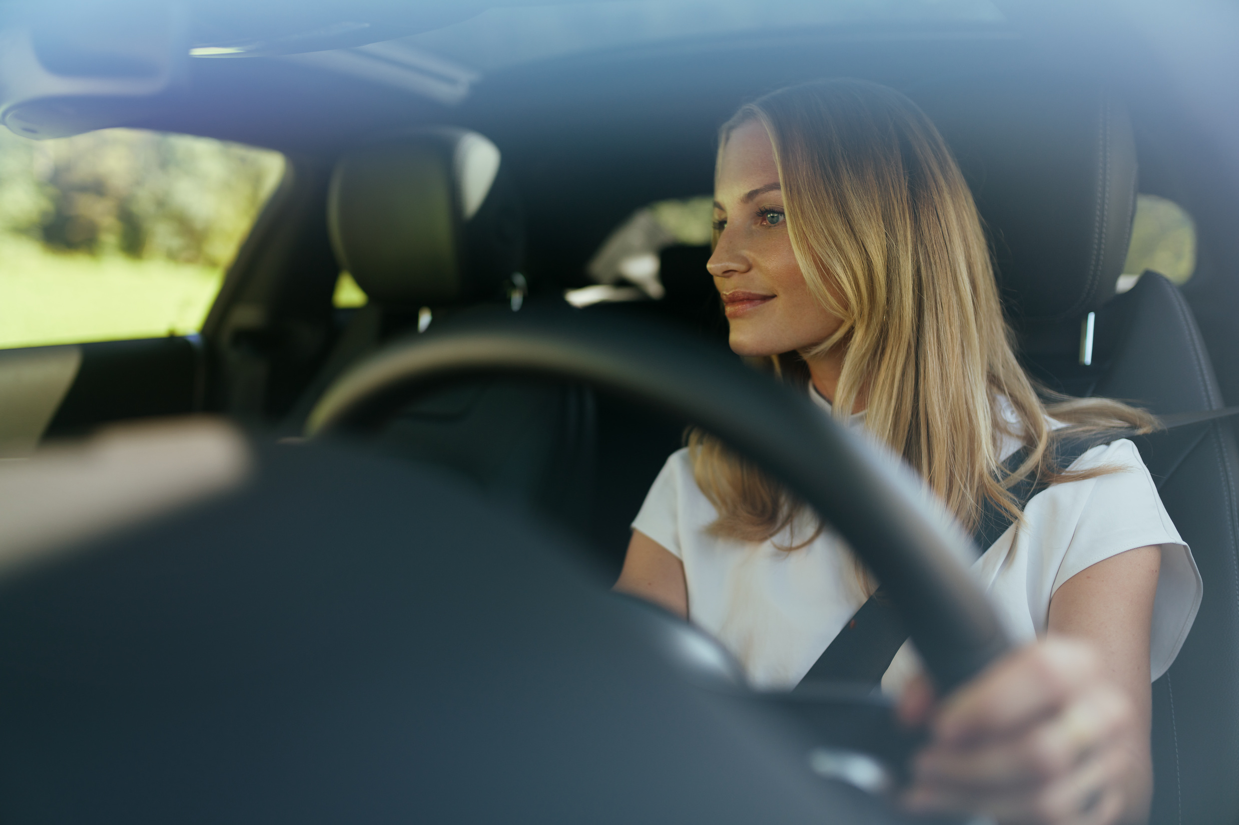 Mercedes-Benz garantisi ile aracınıza rahatlamış bir şekilde binin. | Mercedes-Benz Rahatlamış bir kadın Mercedes'inin direksiyonunda oturuyor.