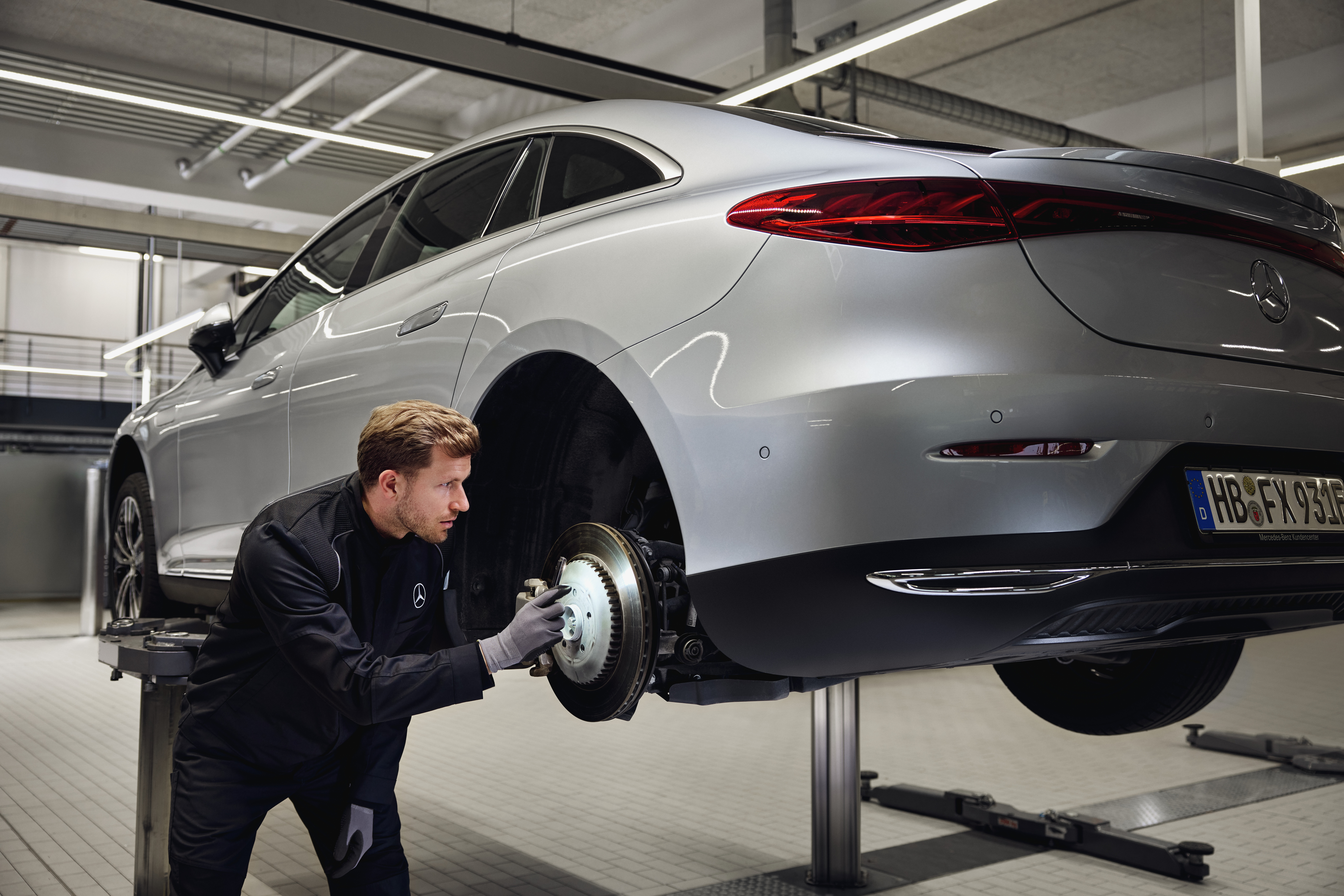Mercedes‑ Benz Orijinal Fren Değişimi Bir Mercedes‑Benz aracı, orijinal parça değişimi için kaldırma platformuna yerleştirilmiş ve bir teknisyen arka fren sistemini kontrol ediyor.