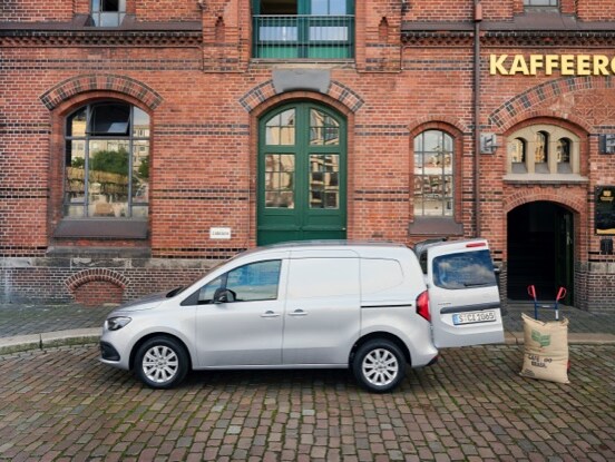 Mercedes-Benz Citan Panelvan Araç, arka kapısı açık bir tuğla binanın önünde duruyor.