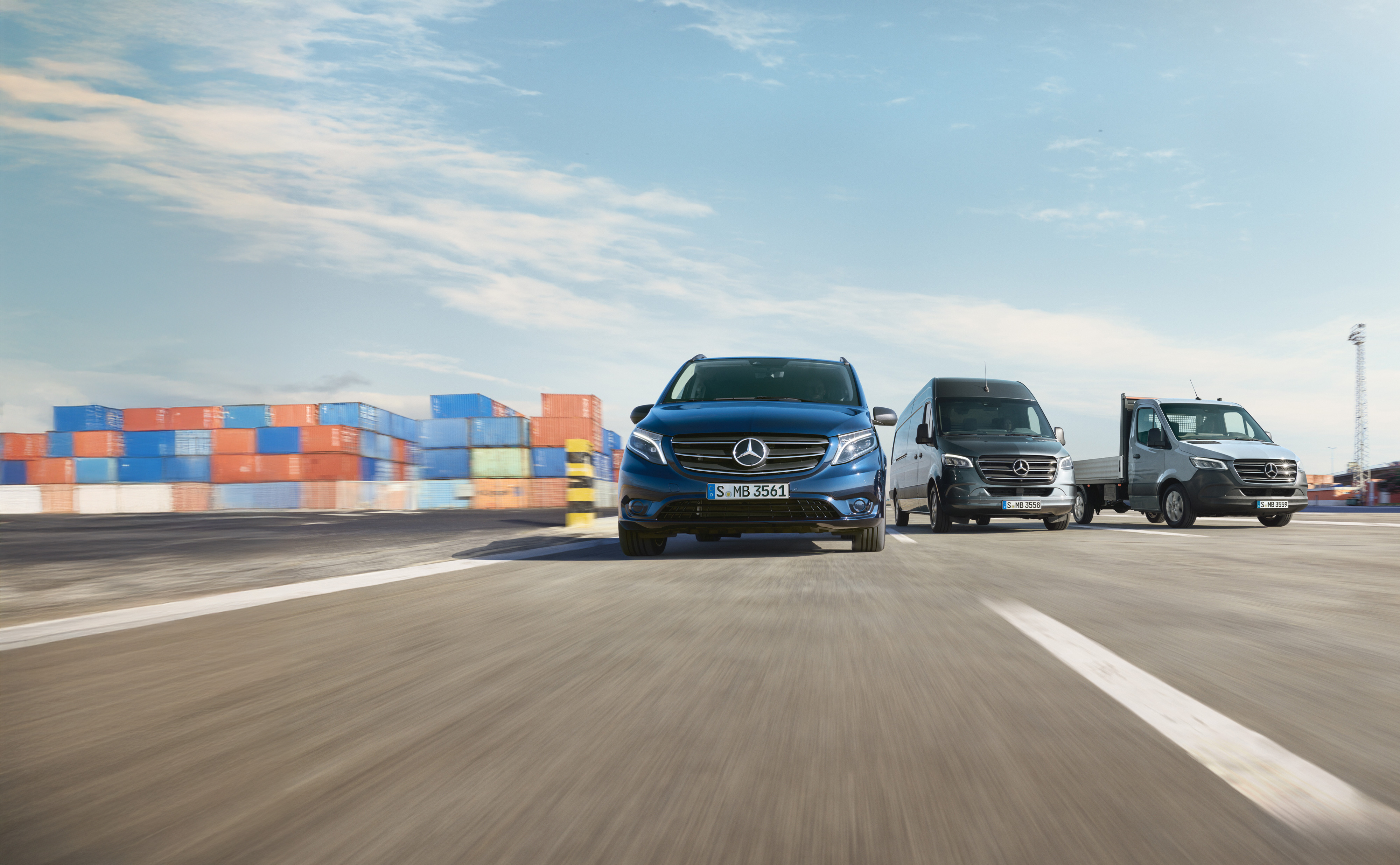 Mercedes-Benz | Hafif ticari araç bakımı | Service24h Kargo limanının yanındaki bir yolda yan yana park etmiş bir dizi Mercedes-Benz hafif ticari araç.