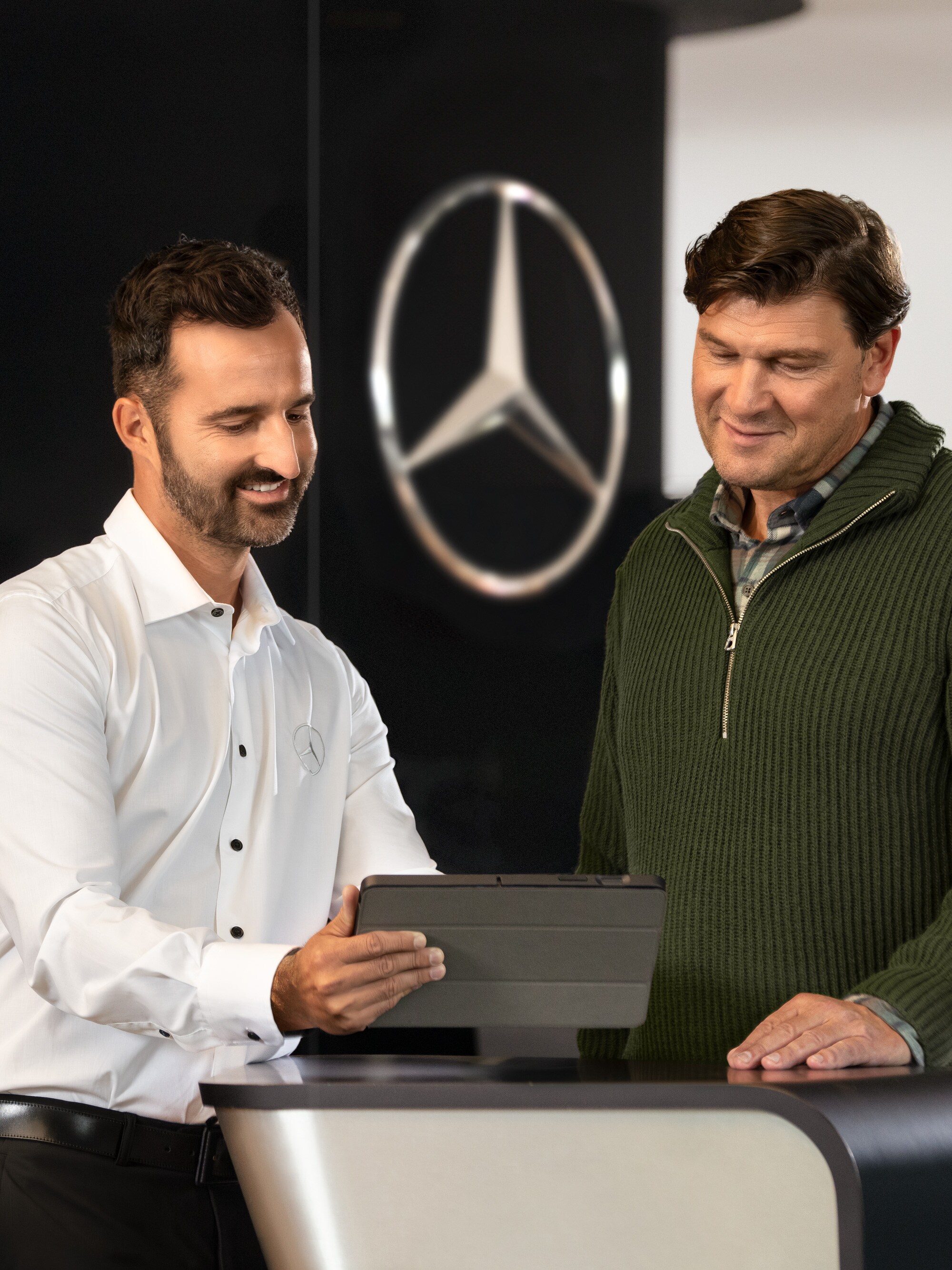 Mercedes personeli bir tabletle müşterilere danışmanlık hizmeti veriyor; bayide kişiye özel destek ve kurumsal danışmanlık.