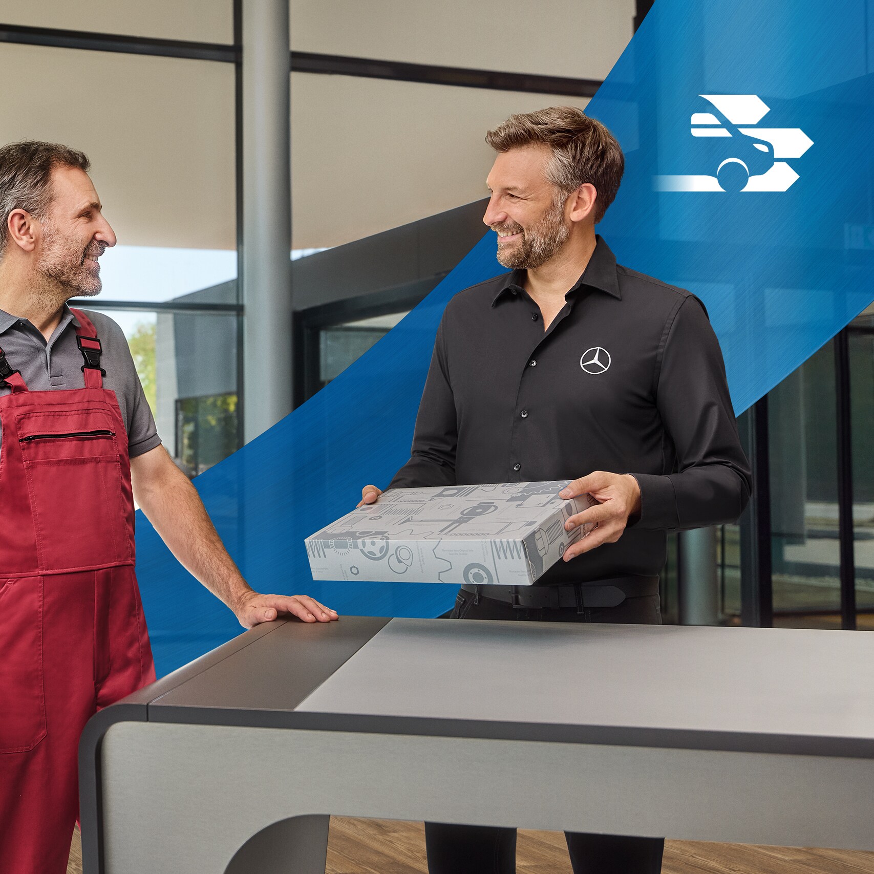 Mercedes-Benz Parça ve Aksesuar Uzmanı, başka bir çalışanla kalite standartları hakkında konuşuyor. Arka plandan geçen dalgalı mavi şerit.