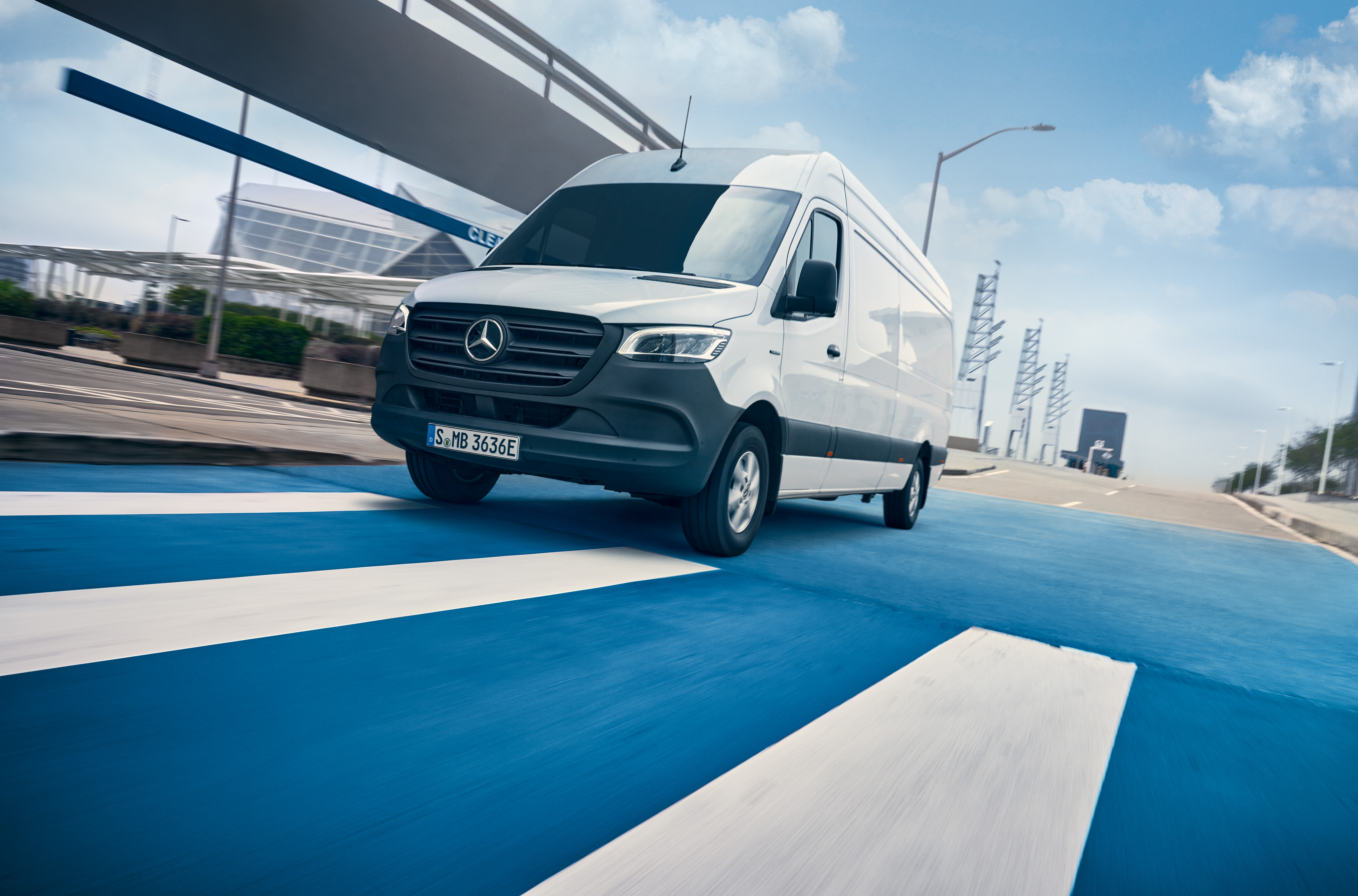 Mercedes-Benz | Hafif Ticari Araç ServiceCare | Bakım paketi Beyaz bir Mercedes-Benz Sprinter sürücüsü şehir içinde yolda sürüş yapıyor.