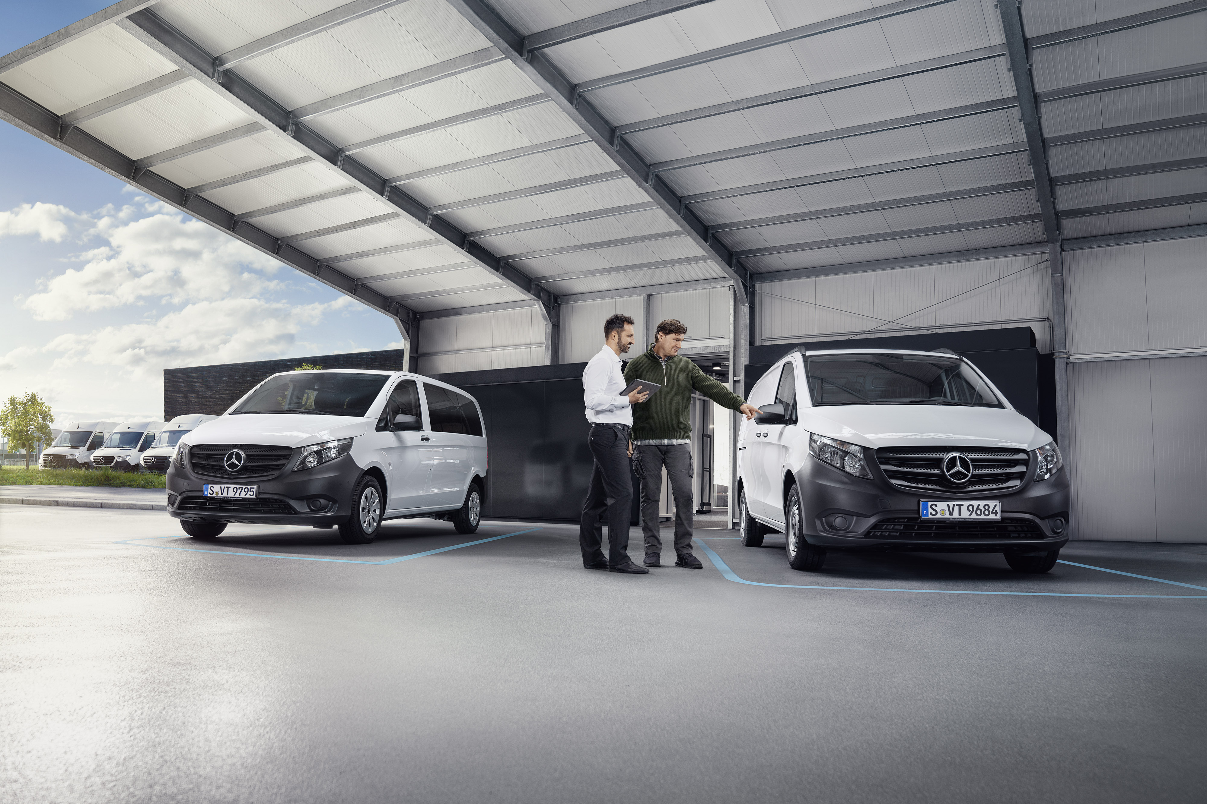 Mercedes-Benz | Geri çağırma Mercedes-Benz müşteri destek temsilcisi, bir servis partneri lokasyonunda bir hafif ticari aracın önünde müşteriyle birlikte.